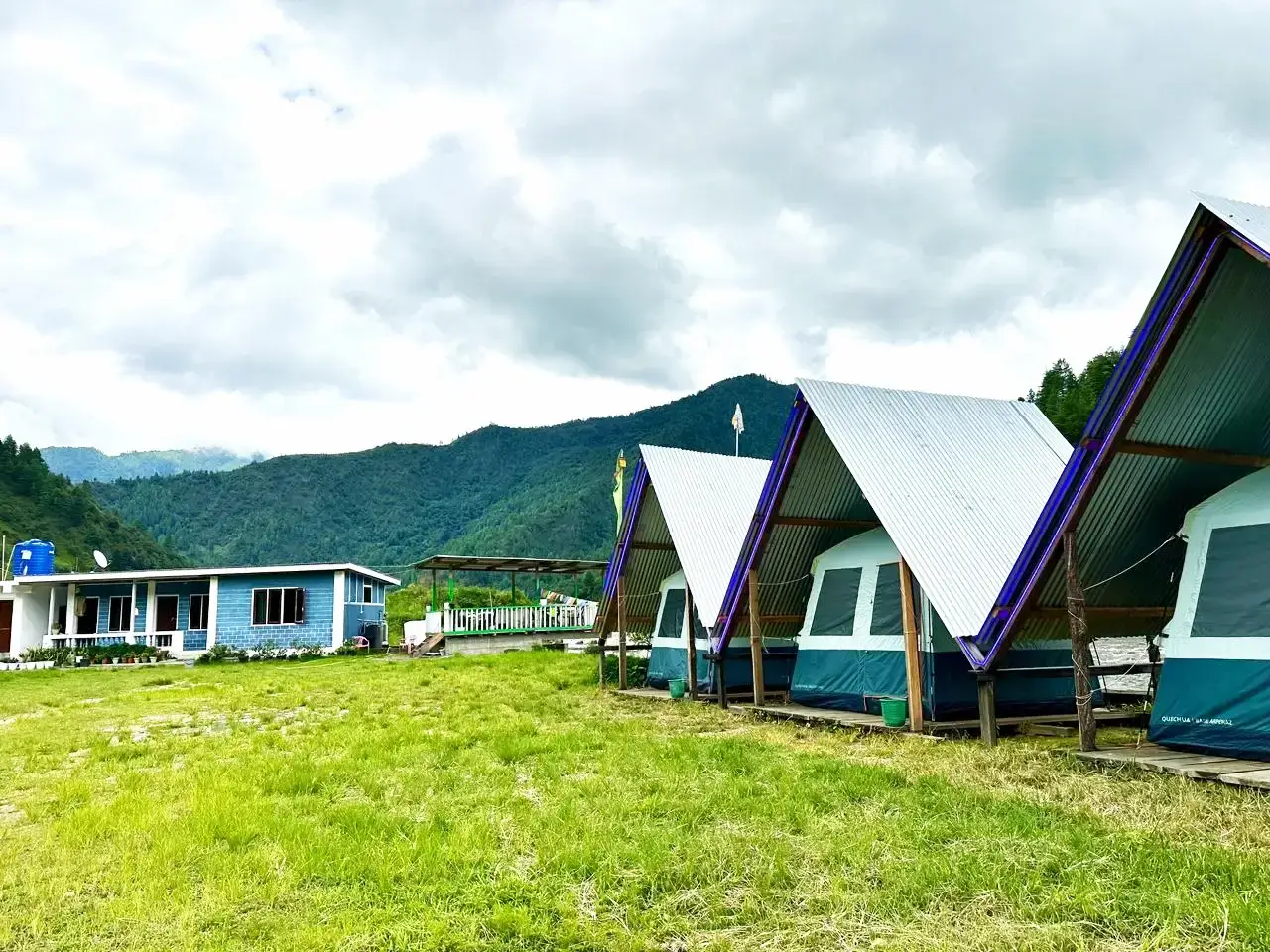 Tents and blue house in field setting at Sangti Valley campsite
